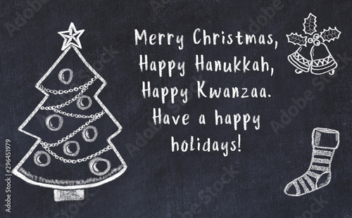 Drawing of christmas tree and handwritten greetings on black chalkboard  photo