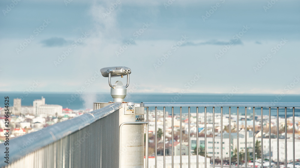 Obraz premium coin binoculars on building looking to the reykjavik city.