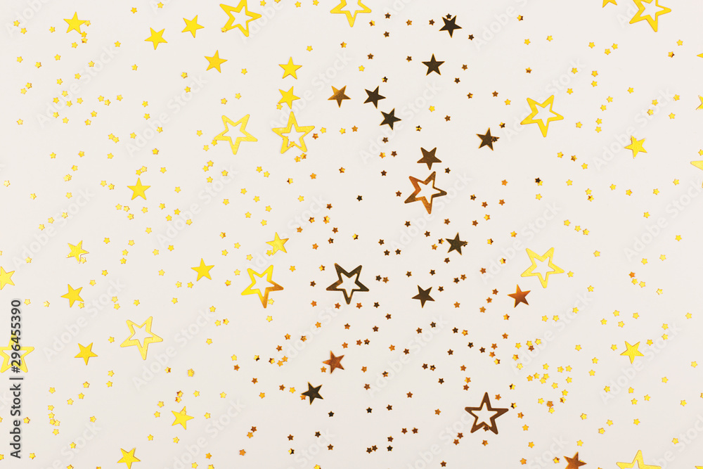 Falling star shape confetti on neutral grey background. Flat lay, top view. 