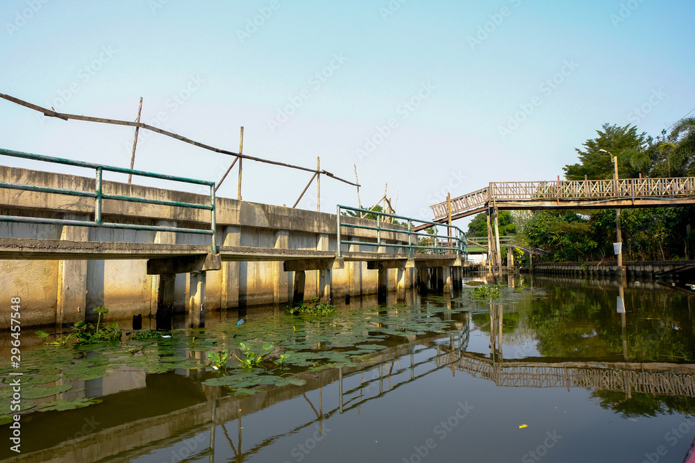 A wooden bridge across a river with water hyacinth in Bangkok,Thailand.
