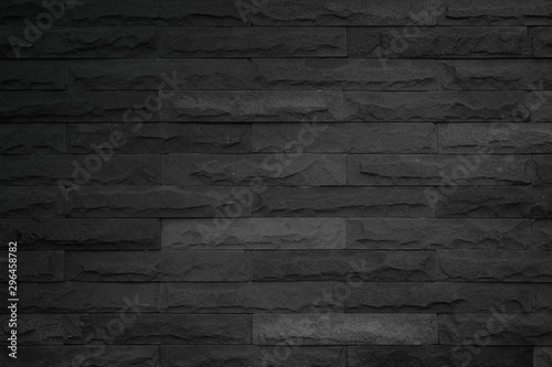 Wall dark black brick texture background. Brickwork or stonework flooring interior backdrop grunge grey wallpaper rock old at pattern concrete grid surface uneven sandstone design for copy space.