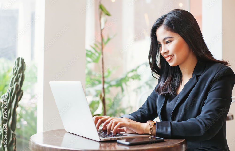 Young asian businesswoman working on a laptop in a cafe Young asian businesswoman working on a laptop in a cafe