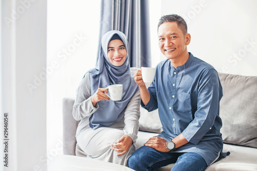 Konstfotografi Beautiful indonesian muslim couple drinking coffee at home