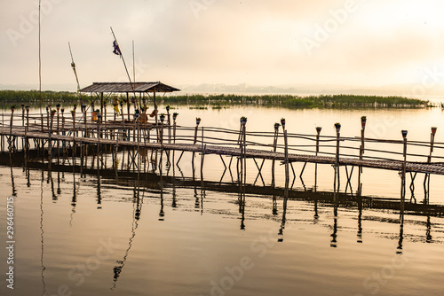 Small wooden bridge with Kwan Phayao lake at sunrise photo