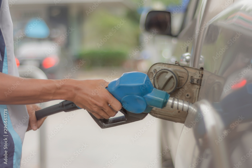 The hands of the employees who are refueling cars