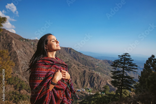 Beautiful woman with closed eyes in front of Himalaya mountains in Dharamshala, India