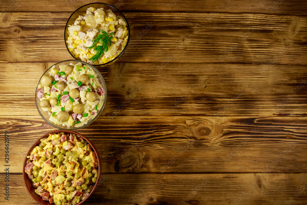 Set of festive mayonnaise salads on wooden table. Top view, copy space Set of festive mayonnaise salads on wooden table. Top view, copy space