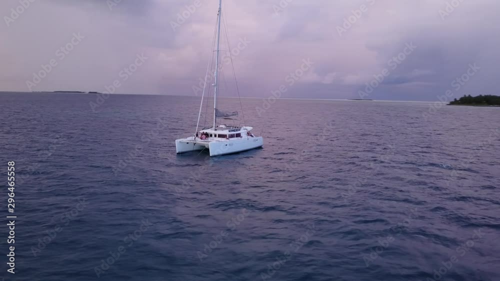 Catamaran, aerial orbit shot. Low down, tropical island. Australia sailing holiday. Relaxing. Catamaran, aerial orbit shot. Low down, tropical island. Australia sailing holiday. Relaxing.
