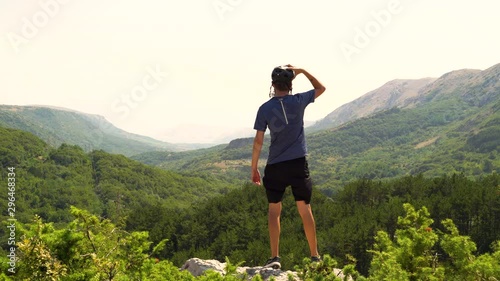 Young cyclist man celebrating at a mountain summit, Croatia.