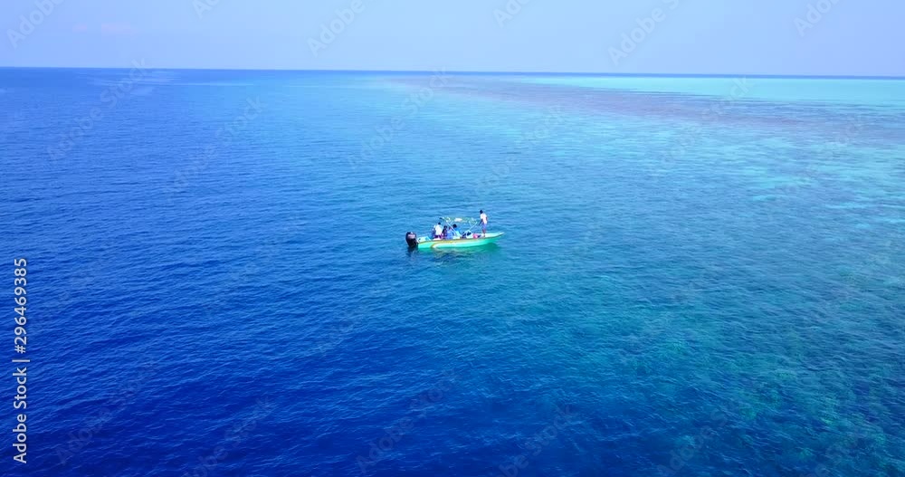 Aerial orbit shot of small boat floating off the coast of the Maldives. Reveals land and island. Aerial orbit shot of small boat floating off the coast of the Maldives. Reveals land and island.