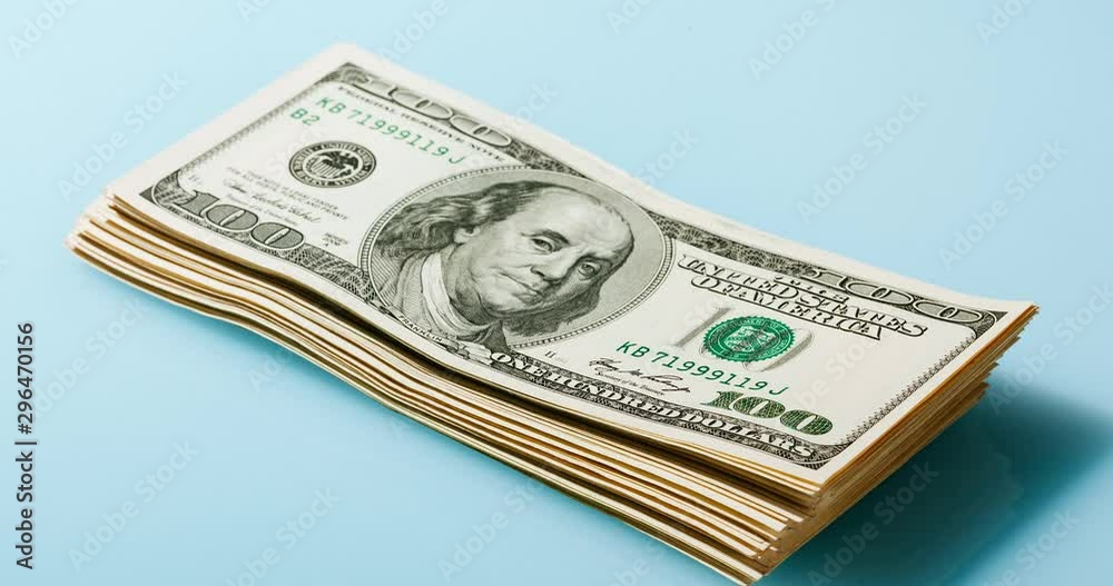 Growing up and down bundle of 100 dollars bills on the blue background, timelapse Growing up and down bundle of 100 dollars bills on the blue background, timelapse