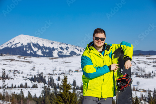 man in sunglasses holding snowboard