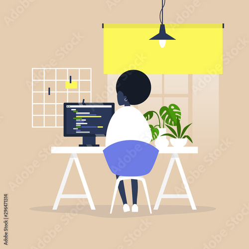 Tech industry, Young black female web developer writing a code on a desktop computer in a modern office