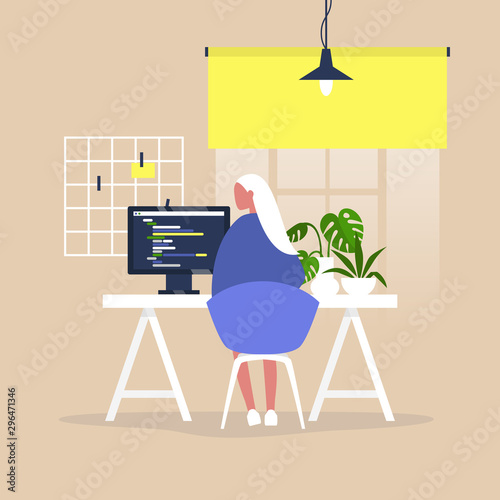 Tech industry, Young female web developer writing a code on a desktop computer in a modern office