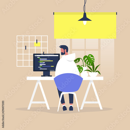 Tech industry, Young male web developer writing a code on a desktop computer in a modern office