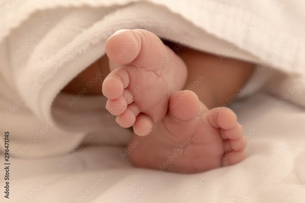 The feet of a newborn baby at a few months old Who is sleeping comfortably on the white mattress During bedtime, the child's brain will work. To enhance Memory-boosting and learning-building skills