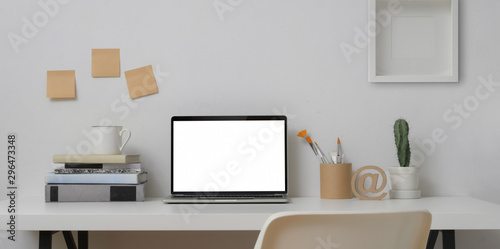 Mock up laptop computer in minimal workplace with painting tools and office supplies