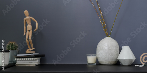 Contemporary workspace and copy space with office supplies and ceramic vase with grey wall