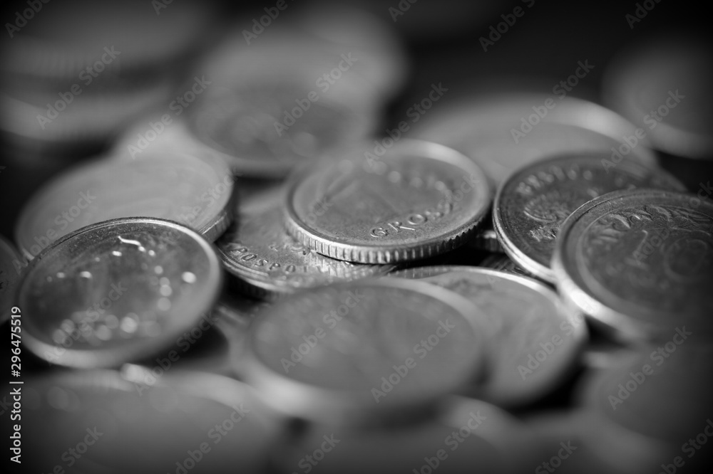 Polish coins scattered on a dark background close up, black and white Polish coins scattered on a dark background close up, black and white