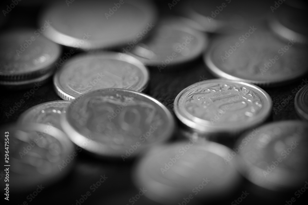 Polish coins scattered on a dark background close up, black and white Polish coins scattered on a dark background close up, black and white