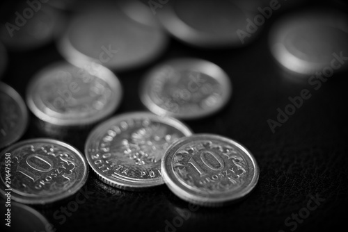 Polish coins scattered on a dark background close up, black and white