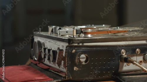 Running tape on reel stopped in old vintage sound recorder rack focus