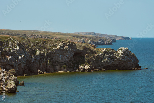 Scenic view of huge cliffs and sea. Dangerous rocky cliffs jagged to ocean. Peaked rocks and cliffs on the seashore