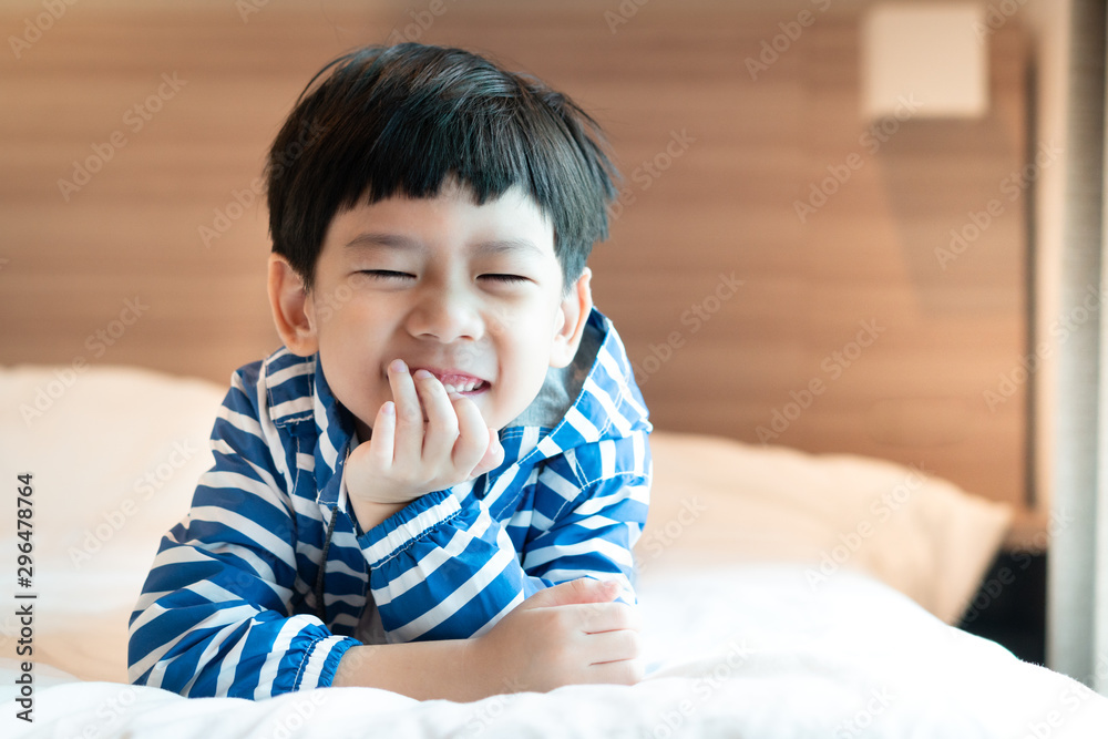 Closeup Portrait of a little well-being cute asian boy in winter outfit lying happily on a warm cozy bed. Raise Happy Kids, Positive, Optimistic, Kids health, Wake Up in Good Mood, Happiness concept. Closeup Portrait of a little well-being cute asian boy in winter outfit lying happily on a warm cozy bed. Raise Happy Kids, Positive, Optimistic, Kids health, Wake Up in Good Mood, Happiness concept.