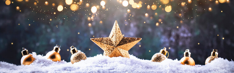 Christmas background with golden star. New Year's decor. Christmas balls in smowdrifts and golden bokeh lights