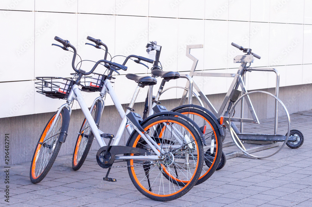 bike with gps navigator in the parking lot, theme of transport and communications. there are bicycles and scooters in the parking lot. people hands using smartphone scanning the QR code of shared bike bike with gps navigator in the parking lot, theme of transport and communications. there are bicycles and scooters in the parking lot. people hands using smartphone scanning the QR code of shared bike