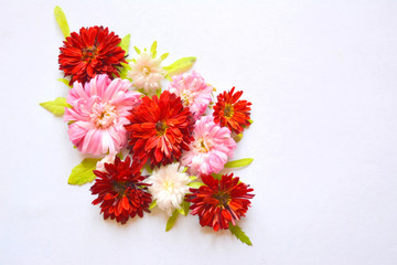Beautiful floral composition with bright red (burgundy) and white flowers and green leaves . Top view, flat lay, copy space 