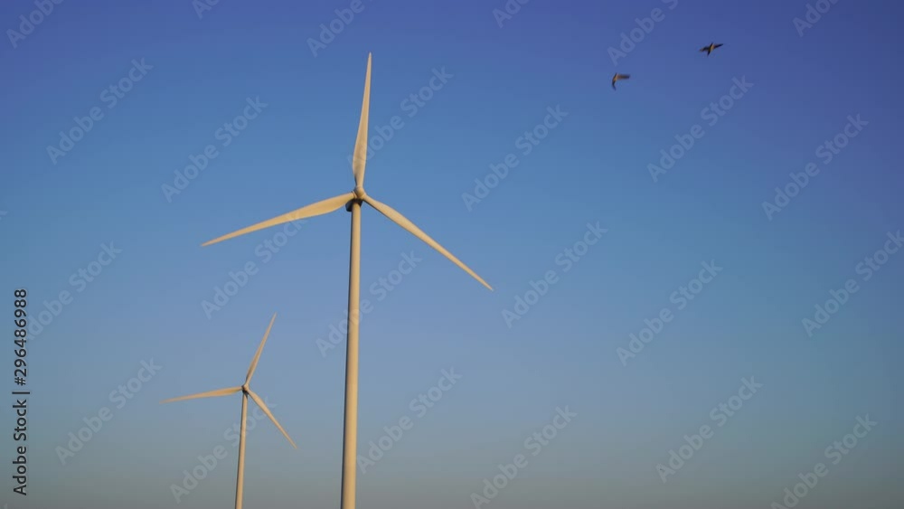 Two modern wind turbines generating clean energy.