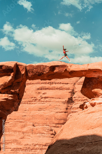 A wild girl jumping across an arch in Jordan