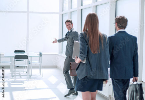Billede på lærred young businessman inviting employees to his new office