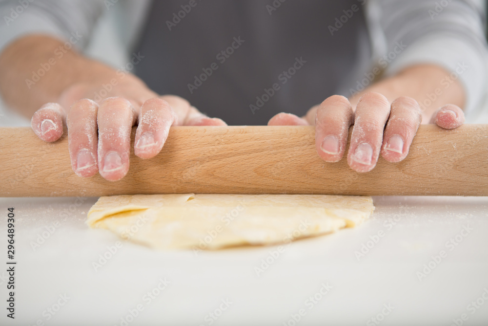 cropped image of hands rolling pastry