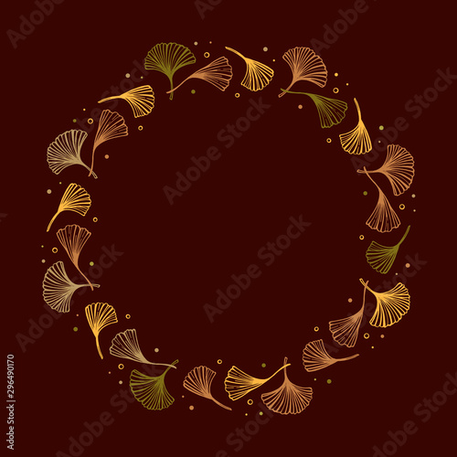 Yellow and green ginkgo leaves round frame in vintage style on brown background.