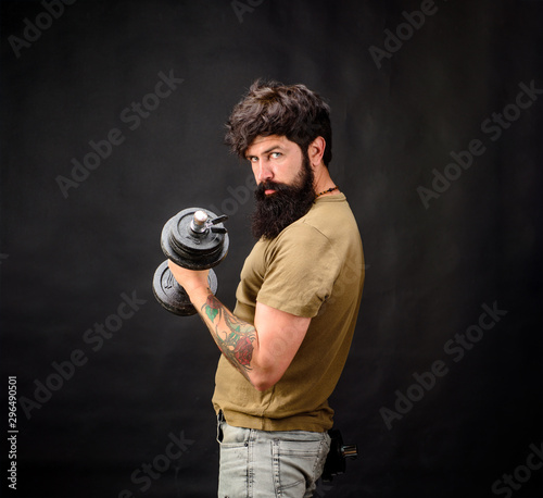 Fitness strong man holds dumbbell. Muscular sportsman with dumbbells training at gym. Handsome athlete man training with dumbbells. Sportsman making weightlifting. Bearded man exercise with dumbbell.