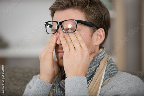 a man rubbing eye at home annoying itch