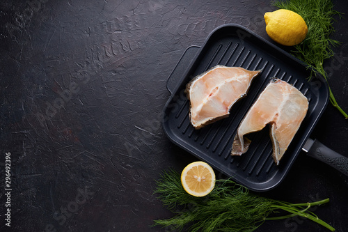 Fresh fillet of sea fish in a grill pan Copy space On dark background. photo