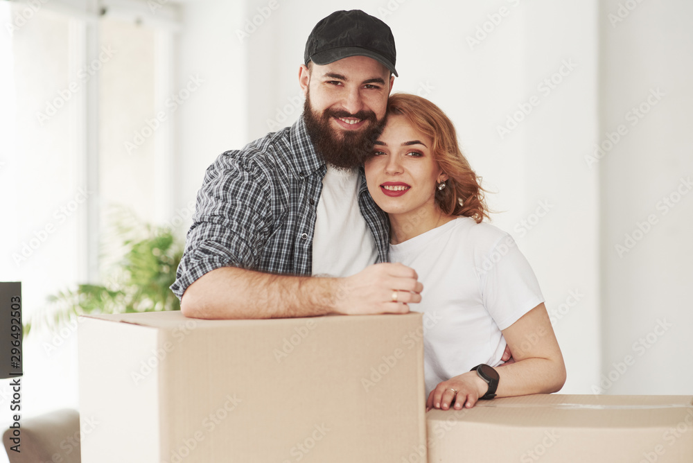 Posing for a camera. Happy couple together in their new house. Conception of moving Posing for a camera. Happy couple together in their new house. Conception of moving