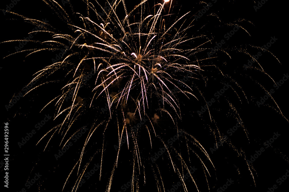 Fireworks in the sky. Salute exploded in a colorful ball in the night sky. Sparks and lights on a black background. Fireworks in the sky. Salute exploded in a colorful ball in the night sky. Sparks and lights on a black background.