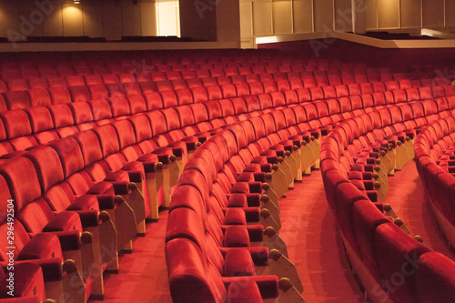 Rows of red cinema seats. View of empty theater hall. Comfort chairs in the modern theater interior