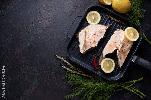 Fresh fillet of sea fish in a grill pan Copy space On dark background. photo