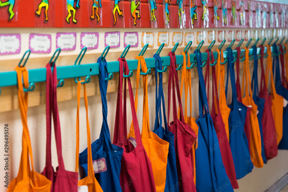 des sacs en tissus dans une école. Des cartables dans le couloir d'une école. Des sacs de tissus colorés aux porte-manteaux d'une école maternelle.