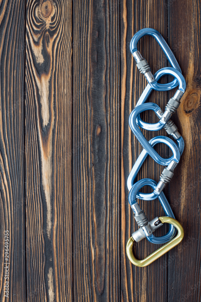 On the right side of the picture. Isolated photo of climbing equipment. Parts of carabiners lying on the wooden table On the right side of the picture. Isolated photo of climbing equipment. Parts of carabiners lying on the wooden table