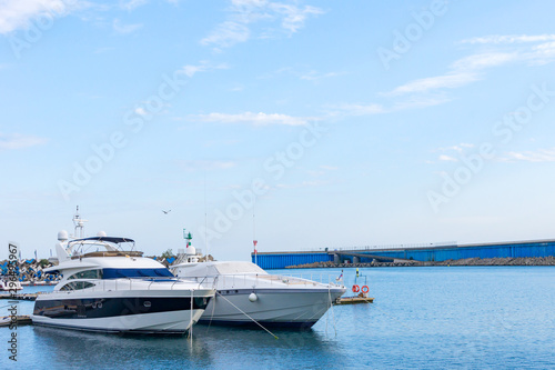 two luxury yachts parked at dock © IKvyatkovskaya