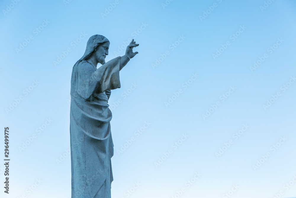 Fototapeta premium Statue of Jesus at Notre Dame in Marseille against a clear blue sky. Side view.