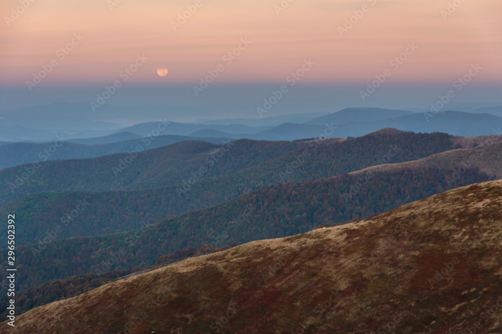 Moonlight in the Ukrainian Carpathians on a mountain ridge with a red tourist tent