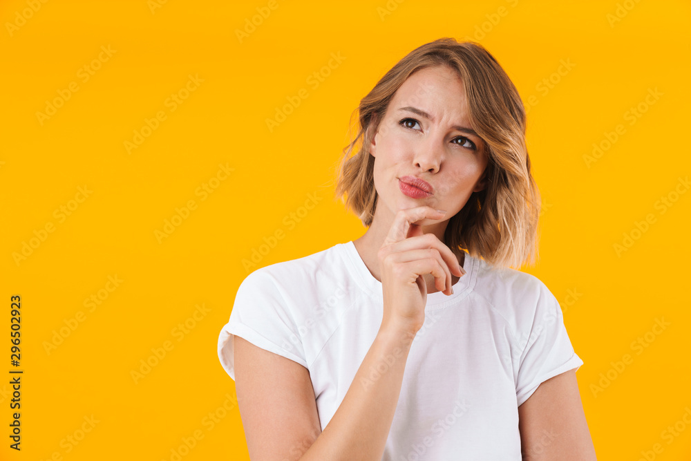 Image of displeased blond woman in casual t-shirt thinking and looking upward Image of displeased blond woman in casual t-shirt thinking and looking upward