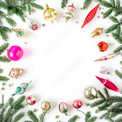 Christmas / New Year holiday composition. Mock up frame with blank copy space, fir needle branches, Christmas baubles, toys, decorations on white background. Flat lay, top view festive concept.